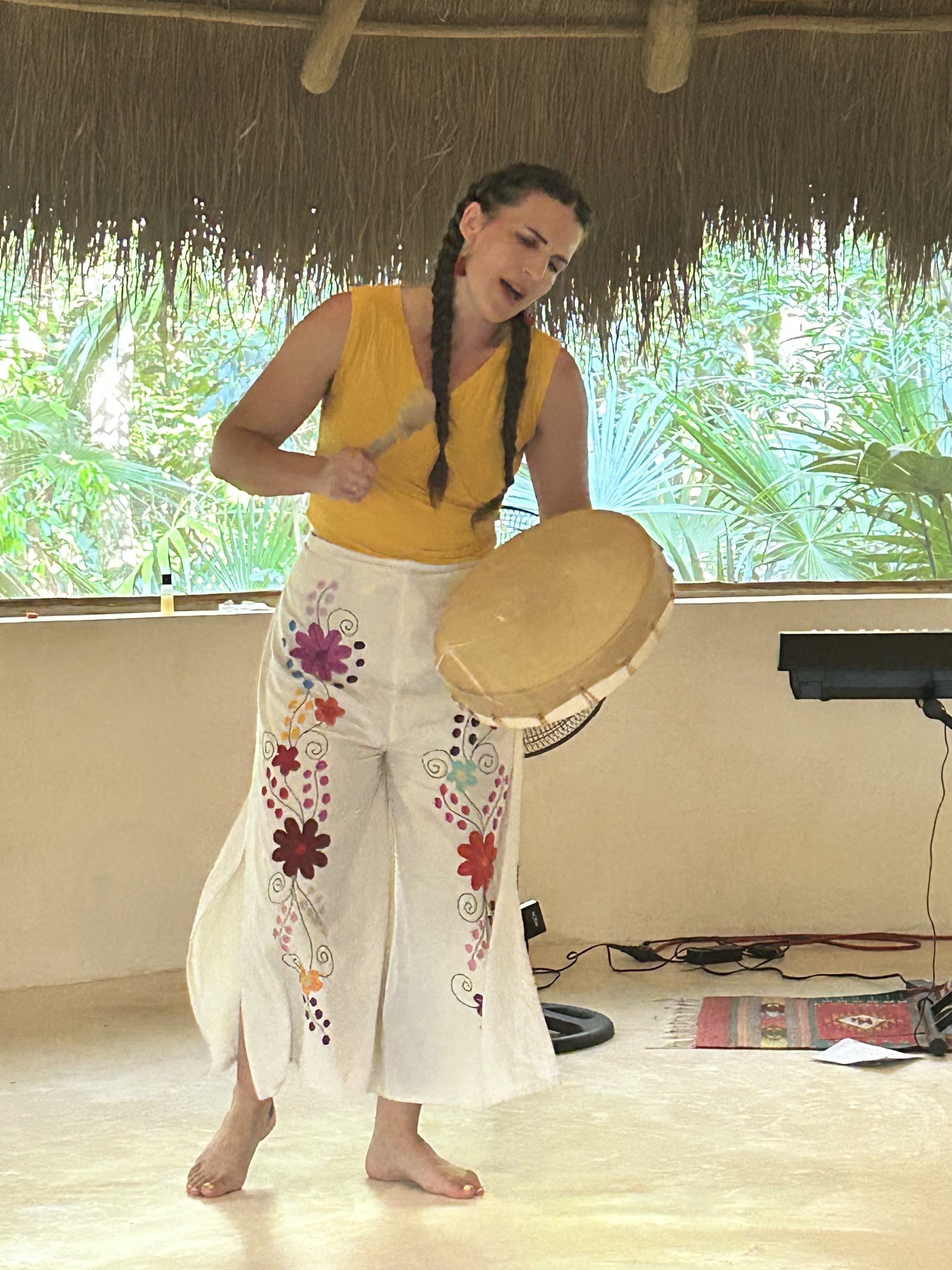 Camille singing with a drum